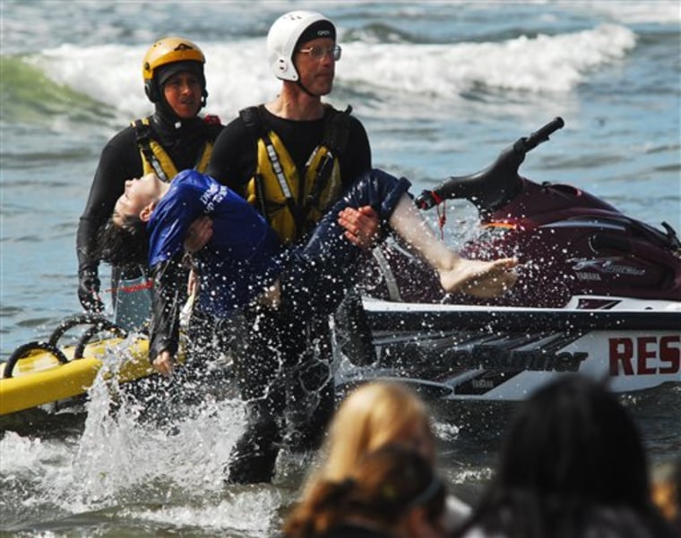 Surf rescue swimmer Doug Knutzen carries 12 year-old Charles Ostrander to the shore of the Cranberry Road beach in Long Beach, Wash., on Aug. 5. Rescue swimmers Eddie Mendez, left, and Will Green found Ostrander in the surf.